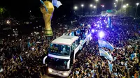 Pemain Timnas Argentina menggunakan bus saat merayakan keberhasilan mereka menjuarai Piala Dunia dengan menggelar parade keliling kota Buenos Aires, Selasa (20/12/2020). (AFP/Tomas Cuesta)