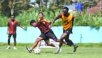 Charles Lokolingoy mencoba menghentikan pergerakan Rifad Marasabessy dalam latihan Arema FC. (Bola.com/Iwan Setiawan)