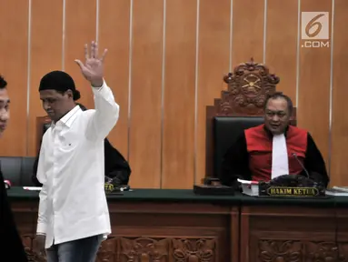 Terdakwa Hercules Rosario Marshal melambaikan tangan usai menjalani sidang perdana di PN Jakarta Barat, Rabu (16/1). Hercules menjalani sidang menggunakan kemeja putih dan peci hitam. (Merdeka.com/Iqbal Nugroho)