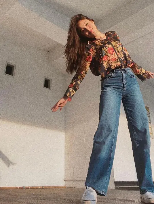 Ini potret Yasmin Napper dengan outfit bernuansa vintage. Kombinasikan shirt motif floral dengan wide leg jeans. (Instagram/yasminnapper).