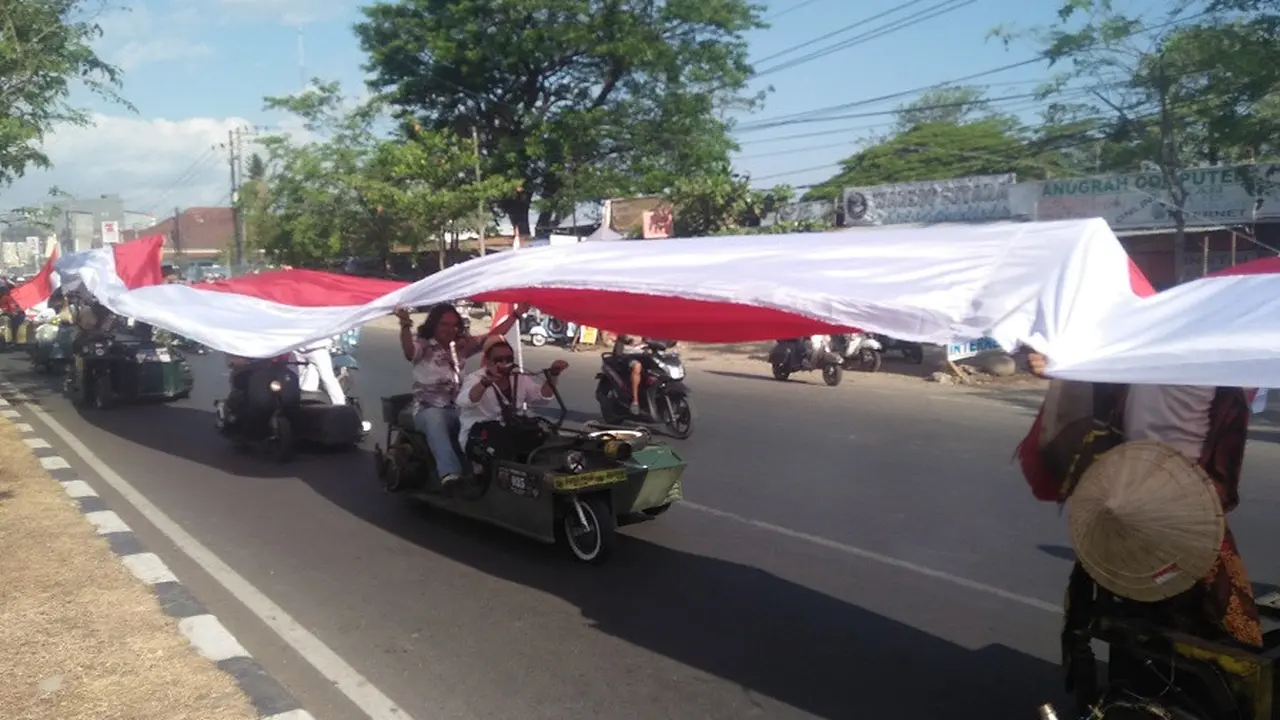 Komunitas vespa di Makassar mengarak bendera merah putih sepanjang 73 meter berkeliling kota Makassar dalam rangka memeriahkan perayaan HUT RI ke-73