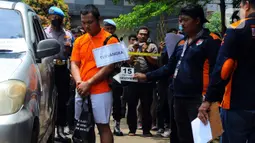 Anggota Densus 88 Bripda Haris Sitanggang alias Bripda HS menjalani rekonstruksi pembunuhan sopir taksi online Sony Rizal Taihitu (56) di lapangan Direktorat Reserse Kriminal Umum Polda Metro Jaya, Jakarta, Kamis (16/2/2023). Bripda HS menjalani 37 adegan sebagai rangkaian peristiwa pembunuhan Sony Rizal Taihitu di Jalan Nusantara Perumahan Bukit Cengkeh, Kelurahan Tugu Cimanggis, Depok, Jawa Barat. (merdeka.com/Imam Buhori)