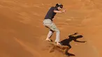 Turis bermain sandboarding (papan seluncur) di gurun Dubai pada 11 Januari 2021. Di sini para wisatawan dapat mencoba sensasi bermain sandboarding sambil memandang hamparan lautan pasir cokelat. (Photo by GIUSEPPE CACACE / AFP)