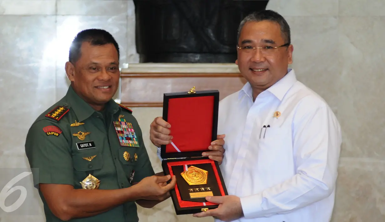 Panglima TNI, Jenderal TNI Gatot Nurmantyo (kiri) memberi cenderamata kepada Menteri Desa PDT dan Transmigrasi Eko Putro Sandjojo usai penandatanganan nota kesepahaman di Jakarta, Rabu (12/4). (Liputan6.com/Helmi Fithriansyah)
