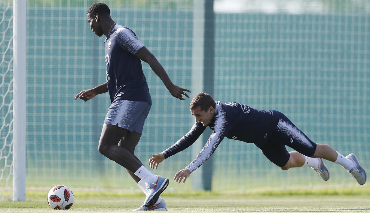 Paul Pogba (kiri) mengecoh Antoine Griezmann saat sesi latihan di Glebovets, Rusia, (12/7/2018). Latihan tersebut sebagai persiapan Prancis melawan Kroasia pada Final Piala Dunia 2018. (AP/David Vincent)