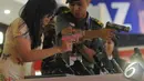 Seorang anggota TNI menunjukkan cara memegang senjata kepada salah seorang pengunjung pameran Indo Defence 2014, JIExpo Kemayoran, Jakarta, Rabu (5/11/2014)(Liputan6.com/Herman Zakharia)
