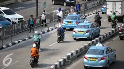 Sejumlah pejalan kaki melintas di trotoar dikawasan Sudirman, Jakarta, Senin (18/4). Gubernur Basuki T Purnama berencana memperlebar trotoar sampai 9,5 meter agar mempermudah orang berjalan kaki usai naik kereta atau bus. (Liputan6.com/Faizal Fanani)