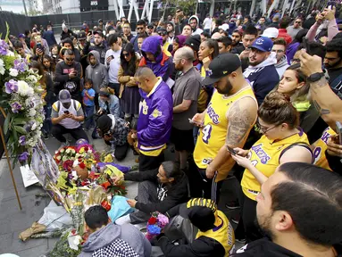 Fans Kobe Bryant berduka saat berkumpul di depan Staples Center, rumah Los Angeles Lakers (26/1/2020). Legenda NBA dan Los Angeles Lakers Kobe Bryant meninggal dunia akibat kecelakaan helikopter di Calabasas, California, Minggu 26 Januari waktu setempat. (AP Photo/Matt Hartman)