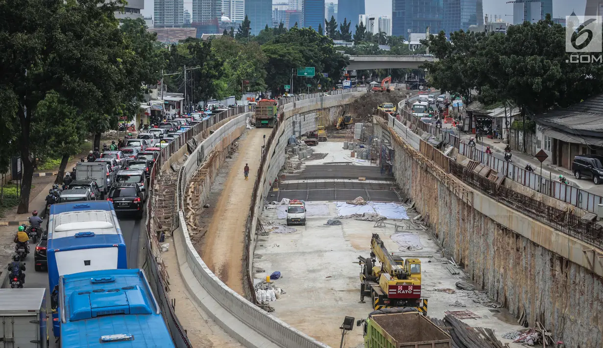 Sejumlah kendaraan melintas di samping proyek pembangunan underpass Mampang-Kuningan di kawasan Mampang, Jakarta, Rabu (27/12). Pengerjaan proyek yang kini telah mencapai 80 persen tersebut ditargetkan selesai pada April 2018. (Liputan6.com/Faizal Fanani)