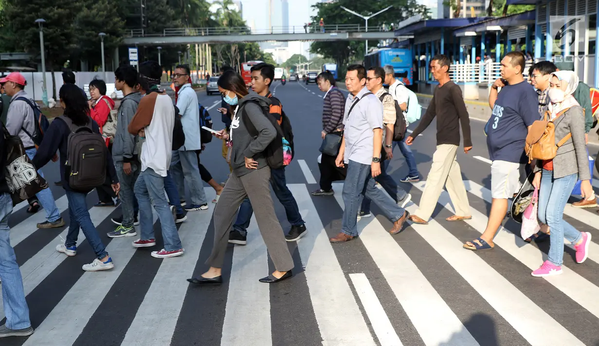 Warga melintasi Pelican Crossing di sekitar Halte Transjakarta Gelora Bung Karno, Jakarta, Jumat, (30/11). Ada tiga jembatan penyeberangan orang (JPO) di Jalan Jenderal Sudirman, Jakarta, yang sedang direvitalisasi. (Liputan6.com/Helmi Fithriansyah)