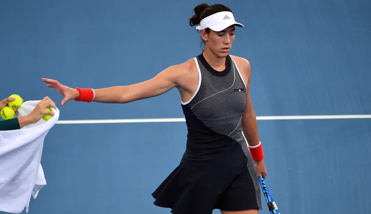Petenis dari Spanyol Garbine Muguruza mengambil bola saat pertandingan putaran kedua melawan Aleksandra Krunic dari Serbia dalam turnamen tenis Brisbane International di Brisbane (2/1). (AFP Photo/Saeed Khan)