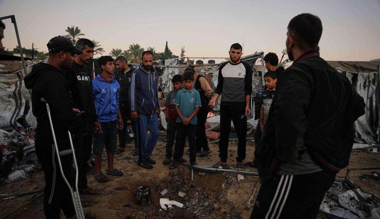 Warga Palestina yang mengungsi memeriksa kerusakan akibat serangan tentara Israel di kamp tenda mereka di Deir al-Balah, Jalur Gaza, Rabu 29 Oktober 2025. Sementara, Hamas menuduh Perdana Menteri Israel Netanyahu mencari-cari alasan untuk menarik diri dari kewajiban Israel berdasarkan perjanjian yang ditengahi AS. (AP Photo/Abdel Kareem Hana)