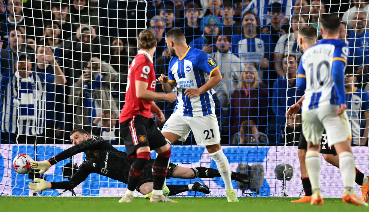 <p>Penjaga gawang Manchester United, David de Gea (kiri), berhasil menggagalkan tendangan dari pemain Brighton, Alexis Mac Allister, dalam pertandingan pertandingan lanjutan Liga Inggris 2022/2023 yang berlangsung di American Express Community Stadium, Kamis (4/5/2023). (AFP/Glyn Kirk)</p>