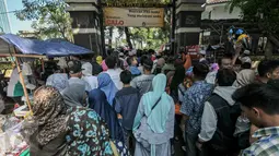 Peziarah berdesakan di pintu masuk TPU Karet Bivak, Jakarta, Rabu (6/7). Padatnya peziarah menyebabkan arus lalu lintas di depan TPU menjadi tersendat karena warga memarkir kendaraan di badan jalan. (Liputan6.com/Yoppy Renato)