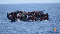 Angkatan Laut (AL) Italia merilis gambar sebuah perahu yang berisi para migran terbalik di lepas pantai Libya, Rabu (25/5). Tujuh orang tewas tenggelam, sementara 500 orang lainnya berhasil diselamatkan dalam insiden tersebut (STR/AFP MARINA MILITARE/AFP)