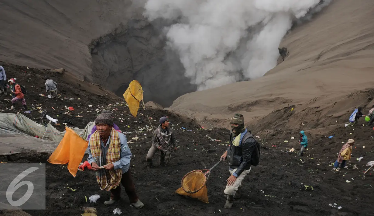 Warga bersiap berebut uang dan hasil bumi yang dilemparkan dari bibir kawah Gunung Bromo, Probolinggo, Kamis (21/7). Warga Tengger melakukan ritual lempar hasil bumi sebagai wujud syukur pada Sang Hyang Widi. (Liputan6.com/Helmi Fithriansyah)
