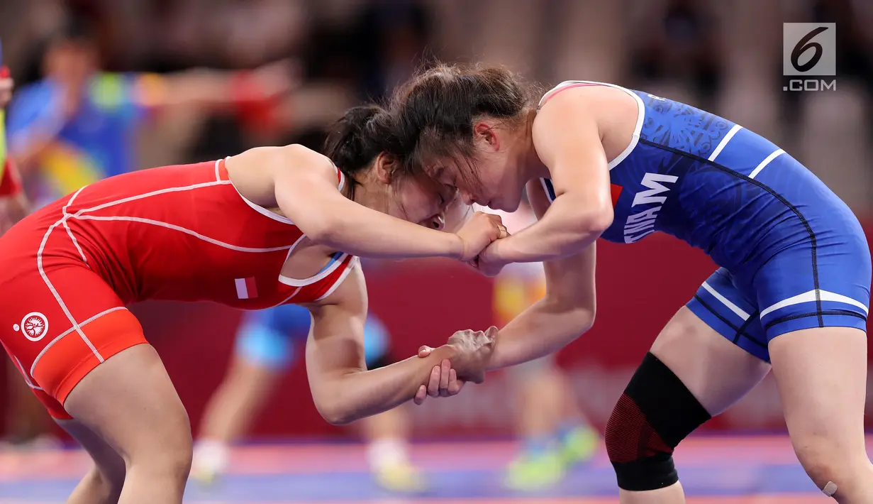 Pegulat Indonesia, Ulfah Dewi (kiri) bertarung dengan pegulat Vietnam, Pham Thi Ha Phuong pada babak perdelapan final Freestyle 53 kg putri dalam Asian Games 2018 di JCC Senayan, Senin (20/8). Ulfah Dewi kalah dengan skor 3-5. (Liputan6.com/Fery Pradolo)