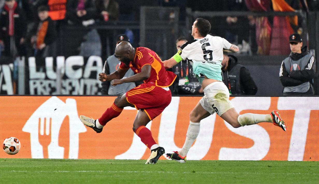 Pemain AS Roma, Romelu Lukaku mencetak gol kedua timnya ke gawang Brighton setelah memanfaatkan kesalahan Lewis Dunk (kanan) pada laga leg pertama 16 besar Liga Europa 2023/2024 di Olympic Stadium, Roma, Italia, Jumat (08/03/2024) dini hari WIB. (AFP/Andreas Solaro)