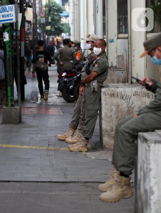 Petugas Satpop PP berjaga di kawasan Pasar Tanah Abang, Jakarta, Rabu (7/7/2021). Satpol PP melakukan penjagaan di seluruh Pasar Tanah Abang mengantisipasi pedagang yang membandel tetap berjualan saat diberlakukannya PPKM Darurat. (Liputan6.com/Angga Yuniar)