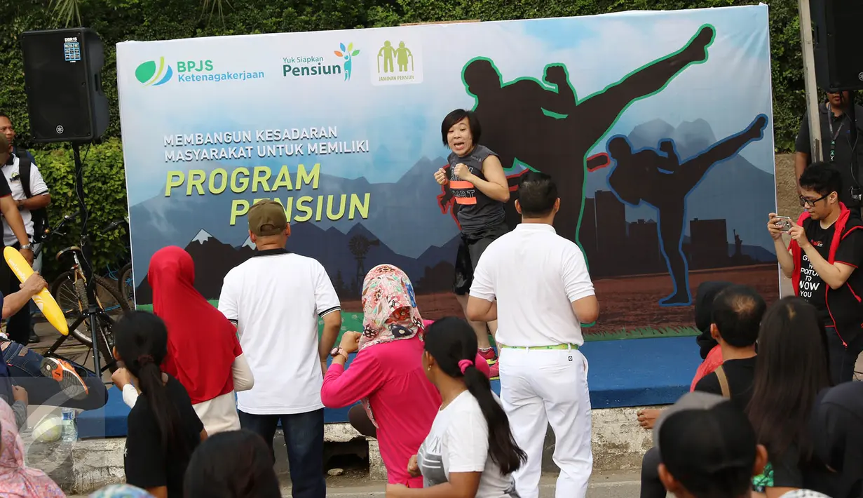 Instruktur mencotohkan gerakan body combat dalam acara sosialisasi bertajuk karnaval pekerja di area CFD, Jakarta, Minggu (14/5). Kegiatan tersebut dilakukan dalam rangka menyemarakkan Hari Pensiun Nasional. (Liputan6.com/Immanuel Antonius)