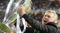 Carlo Ancelotti tersenyum lebar pamerkan trofi Liga Champions (MIGUEL RIOPA / AFP)