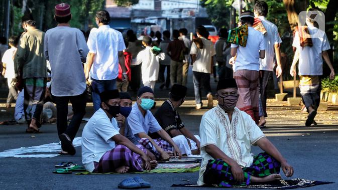 Warga usai melaksanakan salat Idul Fitri 1441 H berjemaah di Masjid Jami Assa'Dah kebayoran Lama, Jakarta, Minggu (24/5/2020). Warga yang hendak salat Id diwajibkan untuk menerapkan protokol kesehatan. (Liputan6.com/Johan Tallo)