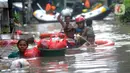 Petugas Pemadam Kebakaran mengevakuasi anak-anak korban banjir dengan menggunakan ban di kawasan Karet Pasar Baru Barat, Jakarta, Selasa (25/2/2020). Banjir yang terjadi sejak subuh akibat luapan Kanal Banjir Barat tersebut merendam ratusan rumah hingga setinggi dua meter. (merdeka.com/Arie Basuki)