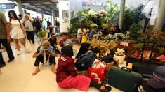 Calon pemudik yang akan menggunakan Kereta Api Jarak Jauh duduk di lantai menanti waktu keberangkatan di Stasiun Pasar Senen, Jakarta, Minggu (7/4/2024). (Liputan6.com/Helmi Fithriansyah)