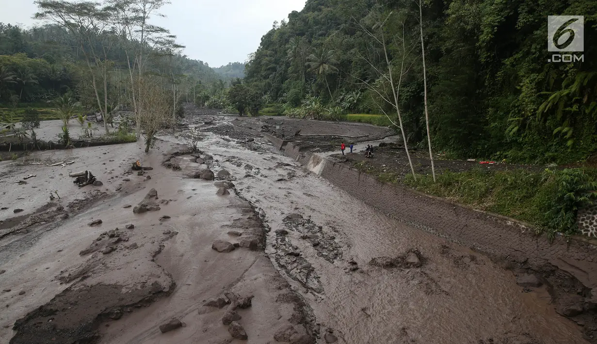 Kondisi aliran Sungai Yeh Sah yang dilintasi lahar dingin dari Gunung Agung di Karangasem, Bali, Sabtu (2/12). Banjir lahar dingin dari Gunung Agung ini menjadi tontonan warga sekitar dan juga pengendara yang melintas. (Liputan6.com/Immanuel Antonius)