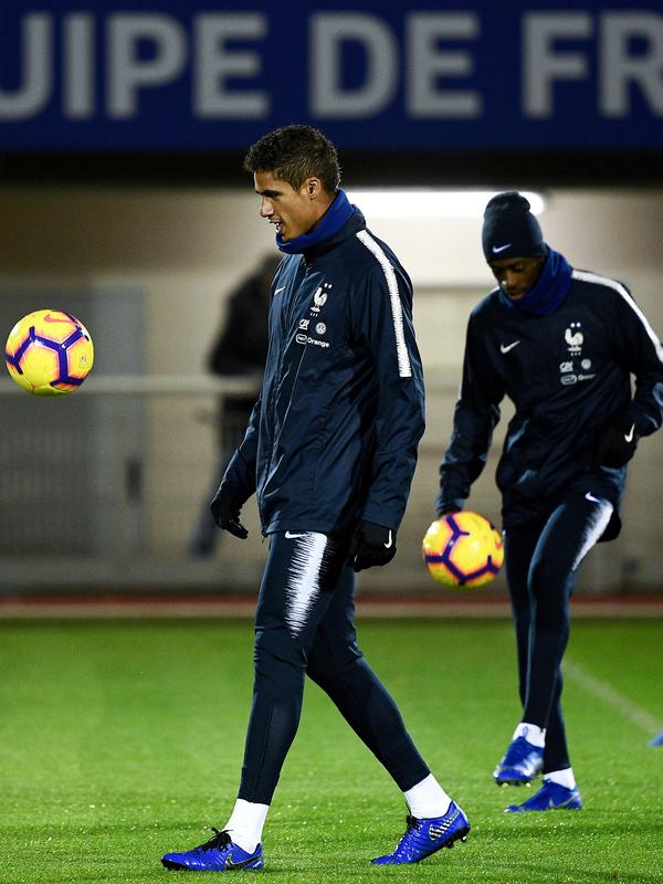 Bek timnas Prancis, Raphael Varane (kiri) dan penyerang Ousmane Dembele menjuggling bola selama sesi latihan di Clairefontaine-en-Yvelines (12/11). Prancis juga akan bertanding pada pertandingan persahabatan melawan Uruguay. (AFP Photo/Franck Fife)