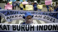 Massa Gabungan Serikat Buruh Indonesia (GSBI) berunjuk rasa di kawasan Patung Kuda, Jakarta, Senin (16/11/2020). GSBI meminta pemerintah mencabut UU Cipta Kerja serta menaikkan upah buruh 2021 sesuai kebutuhan rill buruh dan keluarga. (Liputan6.com/Faizal Fanani)