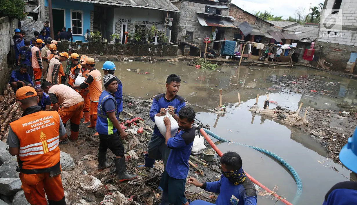 Petugas Suku Dinas Sumber Daya Air dan PPSU mengganjal tanggul yang jebol dengan karung pasir di kawasan Jatipadang, Jakarta, Selasa (12/12). Untuk kesekian kalinya dalam waktu berdekatan, tanggul darurat Kali Pulo jebol. (Liputan6.com/Immanuel Antonius)