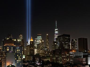 Instalasi cahaya bertajuk 'Tribute in Light'  menerangi langit di lower Manhattan, New York, Selasa (10/9/2019). Cahaya kembar berwarna biru tersebut dinyalakan untuk memperingati 18 tahun peristiwa serangan gedung kembar World Trade Center (WTC)  pada 11 September 2001 silam. (AP/Mark Lennihan)