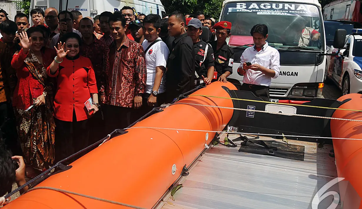 Megawati Soekarnoputri melambaikan tangan saat melepas kader yang membawa bantuan untuk daerah yang tertimpa bencana di acara HUT PDIP ke-42, Jakarta, Sabtu (10/1/2015). (Liputan6.com/Johan Tallo)