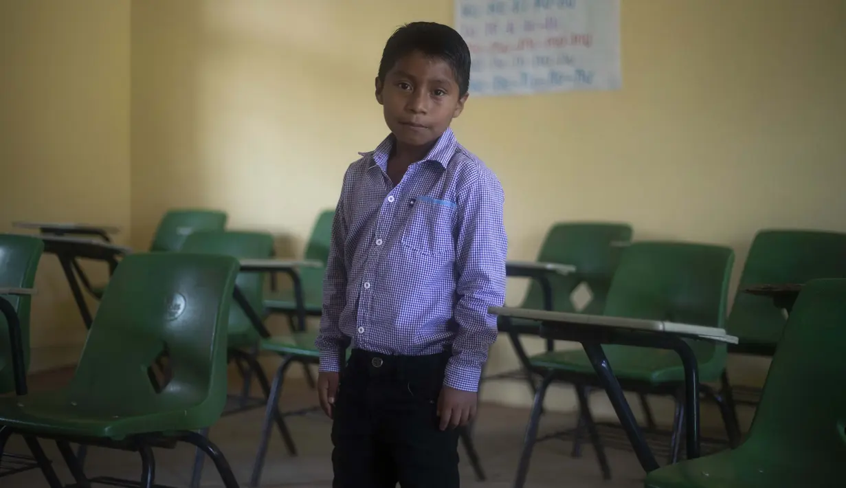 Hector Vasquez berpose dalam bekas ruang kelasnya yang tutup akibat pandemi COVID-19 di Nuevo Yibeljoj, Chiapas, Meksiko, 11 September 2020. Sejak sekolah ditutup pada Maret lalu, Vasquez menghabiskan waktu untuk bekerja di ladang kopi setiap hari. (AP Photo/Eduardo Verdugo)