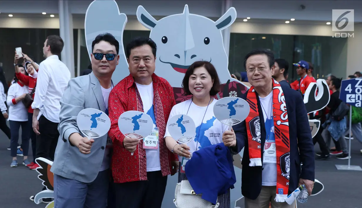 Pendukung tim Korea Bersatu berfoto jelang menyaksikan seremoni pembukaan Asian Games 2018 di Stadion GBK, Jakarta, Sabtu (18/8). Asian Games 2018 akan berlangsung hingga 2 September, mendatang. (Liputan6.com/Helmi Fithriansyah)