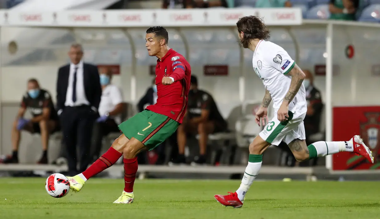 Pemain Portugal Cristiano Ronaldo (kiri) mengoper bola saat melawan Irlandia pada pertandingan kualifikasi grup A Piala Dunia 2022 di Stadion Algarve, luar Faro, Portugal, Rabu (1/9/2021). Ronaldo mencetak dua gol saat Portugal menang 2-1. (AP Photo/Armando Franca)