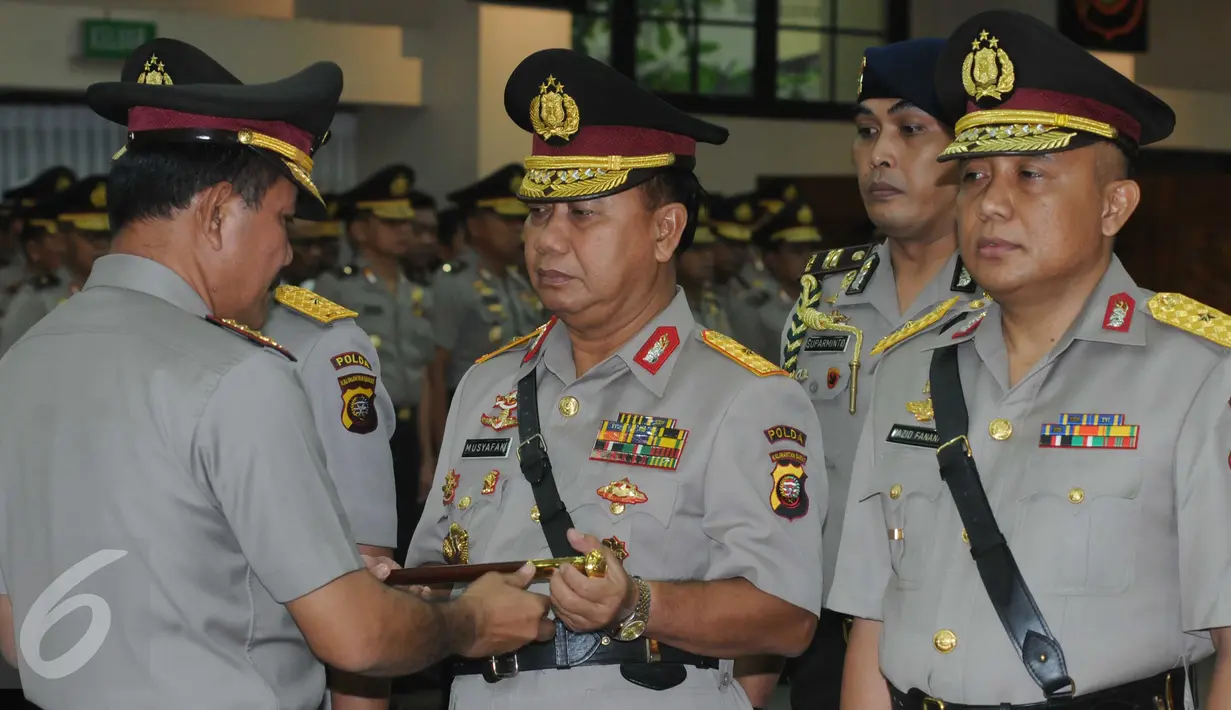 Kapolri Jenderal Polisi Badrodin Haiti menyerahkan tongkat komando kepada Brigjen Musyafak saat upacara sertijab di Gedung Rupatama, Mabes Polri, Jakarta, Selasa (31/5). Brigjen Musyafak resmi menjadi Kapolda Kalimantan Barat. (Liputan6.com/Helmi Afandi)