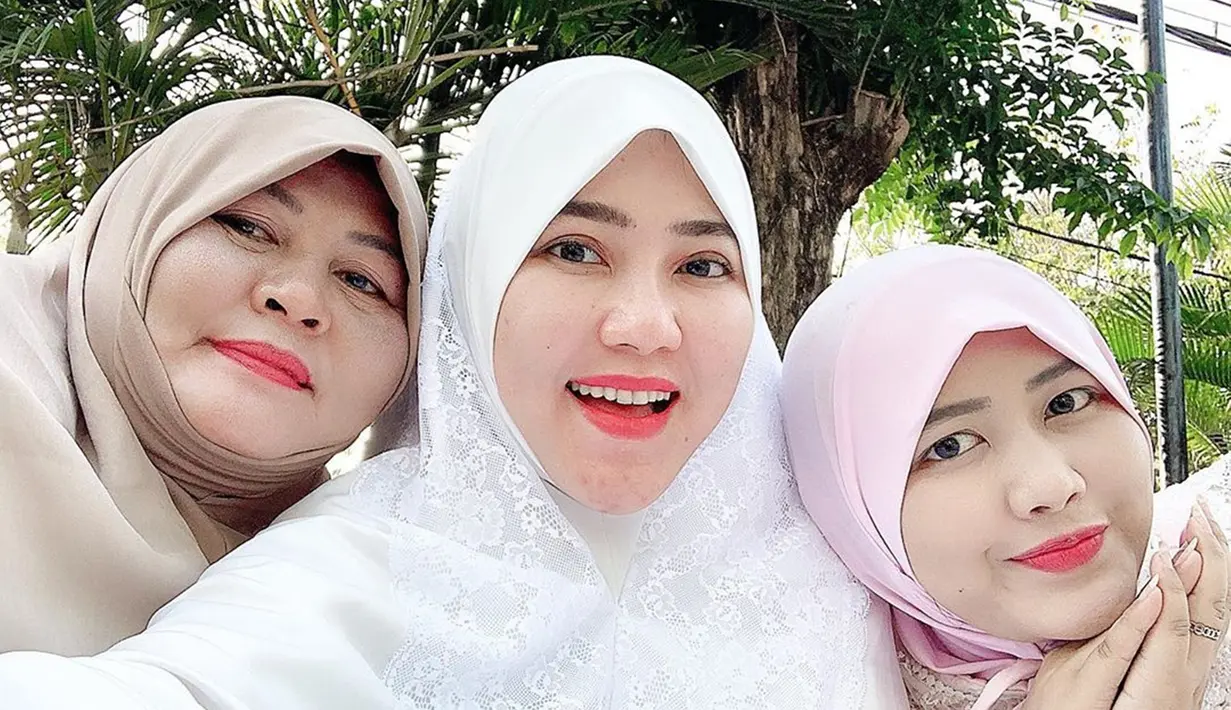 Perempuan kelahiran 1 Oktober 1991 ini sangat dekat dengan keluarganya. Seperti saat momen Via Vallen merayakan hari raya Idul Fitri bersama keluarga besarnya. Dengan diapit ibu dan adiknya, Via dengan cantiknya memakai hijab warna putih. (Liputan6.com/IG/@viavallen)