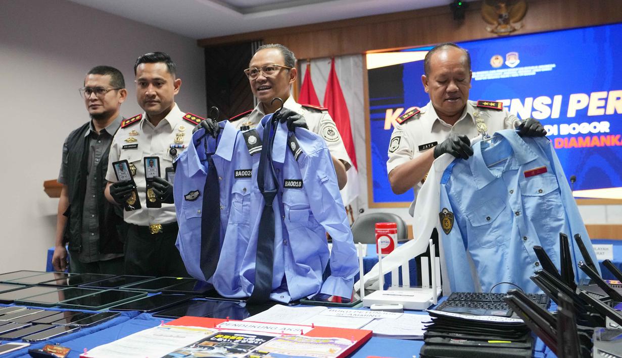 Dari hasil pemeriksaan dokumen, didapati bahwa satu orang di antaranya tidak mampu menunjukkan paspor asli. Tampak dalam foto, petugas Imigrasi memperlihatkan seragam dan lencana polisi Jepang palsu yang disita dari warga negara Jepang yang diduga terlibat dalam sindikat penipuan daring (online), di Bogor, Jawa Barat, Rabu 4 Maret 2026. (AP Photo/Achmad Ibrahim)