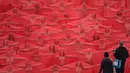 Ratusan orang berpose mengenakan kain merah transparan saat foto bugil massal di atap sebuah supermarket di Melbourne (9/7). Pemotretan ini memiliki tema apokaliptik,  yang mengingatkan pada serial TV The Handmaid's Tale. (AFP Photo/Paul Crock)