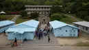 Pengunjung berpose saat mengunjungi replika desa perbatasan zona demiliterisasi (DMZ) Panmunjom di Namyangju, Korea Selatan, Sabtu (5/5). Replika ini dibangun untuk set film thriller-misteri blockbuster 2000, JSA: Joint Security Area. (AFP/Ed JONES)