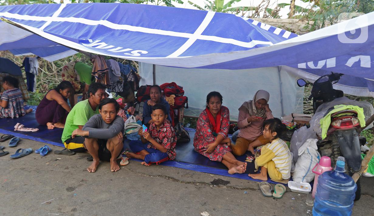 Warga mengungsi di tenda yang didirikannya di jalan Desa Sumber Urip Pebayuran, Senin (22/2/2021). Sudah tiga hari warga bertahan di tenda pengungsian dikarenakan banjir luapan sungai Citarum yang merendam permukiman warga kampung Babakan Banten Pebayuran. (Liputan6.com/Herman Zakharia)