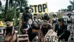Aktivis Greenpeace Indonesia bersama beberapa pemuda Papua menggelar aksi teatrikal saat berunjuk rasa di depan Kantor Kementerian Koordinator bidang Perekonomian, Jakarta, Kamis (18/12/2025). Aktivis Greenpeace Indonesia bersama beberapa pemuda Papua menggelar aksi damai di depan Kantor Kementerian Koordinator bidang Perekonomian, Jakarta. (Yasuyoshi Chiba/AFP)