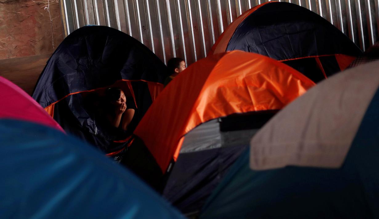 Seorang wanita imigran duduk di tenda tempat penampungan di Tijuana, Meksiko 6 April 2019. Rombongan migran Amerika Tengah mencapai kota perbatasan antara Meksiko dan AS tersebut  untuk mencari suaka akibat kekerasan, pembunuhan dan kemiskinan yang mengancam mereka. (REUTERS/Carlos Jasso)