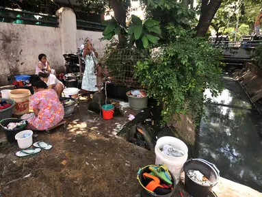 Warga mencuci pakaian di pinggir jalan kawasan Kramat Pulo, Senen, Jakarta, Kamis (27/12). Minimnya tempat MCK pribadi memaksa warga di Kramat Pulo menggunakan lahan di pinggir jalan untuk mencuci pakaian dan piring mereka. (Merdeka.com/Iqbal S. Nugroho)