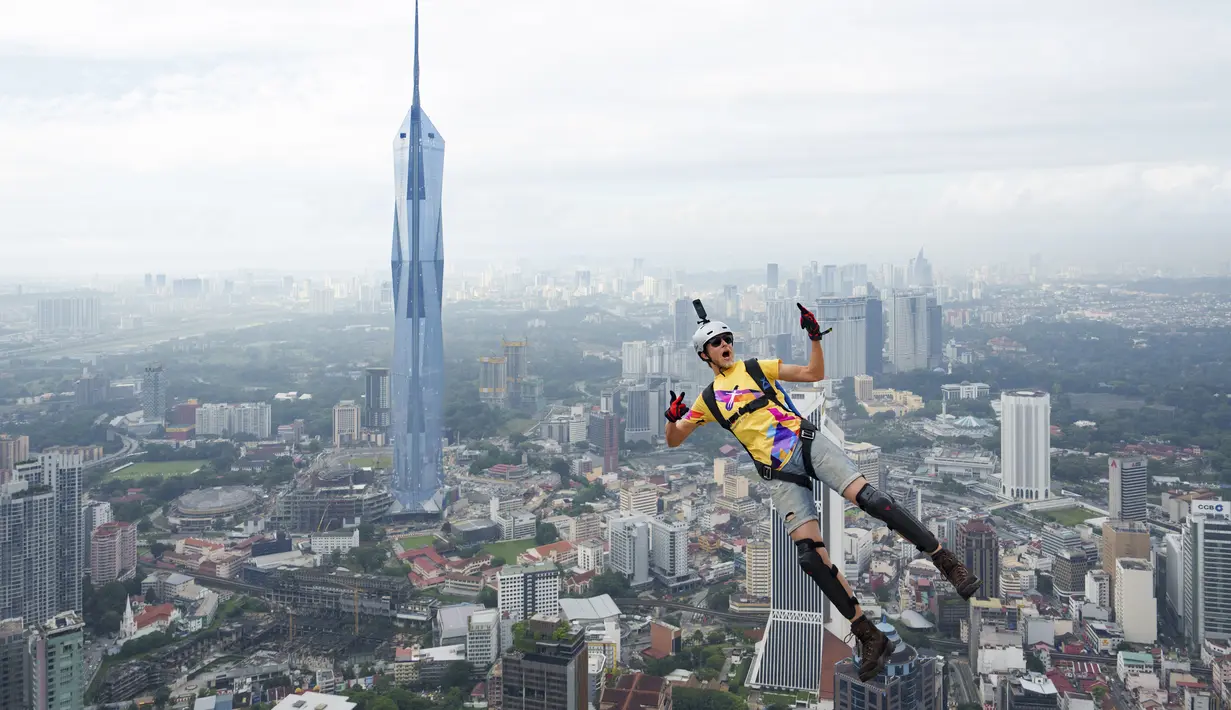 Seorang pelompat BASE terjun dari Menara Kuala Lumpur selama KL Tower International Jump Malaysia di Kuala Lumpur, Jumat (3/2/2023). Satu persatu peserta pemberani, ada juga yang sekaligus berdua, meloncat sambil membawa parasut masing-masing. (AP Photo/Vincent Thian)