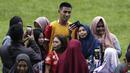Pemain Arema FC, Hanif Sjahbandi, foto bersama dengan fans usai sesi latihan di Stadion Gajayana, Malang, Kamis (11/4). Setelah sesi latihan, pemain Arema FC melayani permintaan fans untuk foto bersama. (Bola.com/Yoppy Renato)