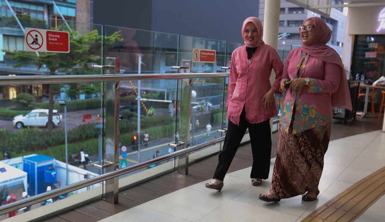 Melawan segala bentuk diskriminasi, Raden Ajeng Kartini berjuang membuka akses untuk perempuan Indonesia agar bisa berkontribusi lebih luas, bukan hanya di lingkungan domestik atau rumah tangga. Tampak dalam foto, beberapa perempuan mengenakan kebaya saat melintas di sekitar kawasan Bundaran Hotel Indonesia, Jakarta, Selasa (21/4/2026). (Kapanlagi.com/Budy Santoso)