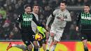 Aksi Cristiano Ronaldo melewati Manuel Locatelli pada laga lanjutan Serie A yang berlangsung di stadion Mapei, Reggio Emilia, Senin (11/2). Juventus menang 3-0 atas Sassuolo. (AFP/Miguel Medina)